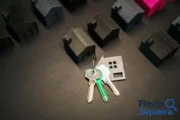 Chaves de casa sobre mesa com miniaturas de imóveis, representando o consórcio imobiliário como forma de conquistar a casa própria.
