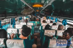 Interior de um ônibus com passageiros sentados durante a viagem, representando a experiência de quem compra passagem de ônibus para deslocamentos urbanos e intermunicipais.