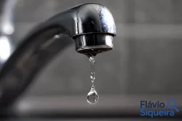 Gota de água caindo de uma torneira, representando atenção ao consumo de água e à economia no uso doméstico.