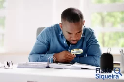 Homem analisando documentos com uma lupa, simbolizando a busca por desconto no IPTU.