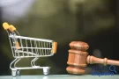 Carrinho de compras ao lado de um martelo de juiz, representando os direitos do consumidor.