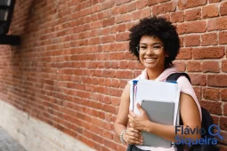 Estudante segurando materiais escolares, simbolizando o pagamento Pé-de-Meia para quem terminou o ensino médio.